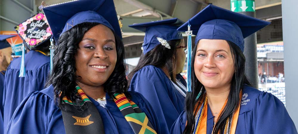 two smiling graduates at commencement