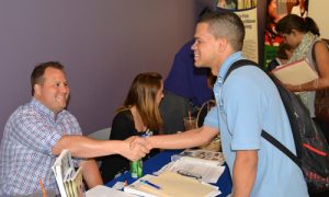 Matt Paradis from CRT shaking hands with Criminal Justice student Alex Stagnaro.