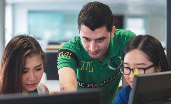 2 students and instructor looking at computer screen