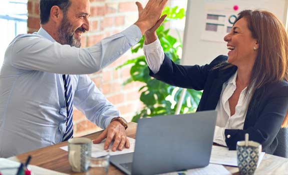 2 co-workers high fiving